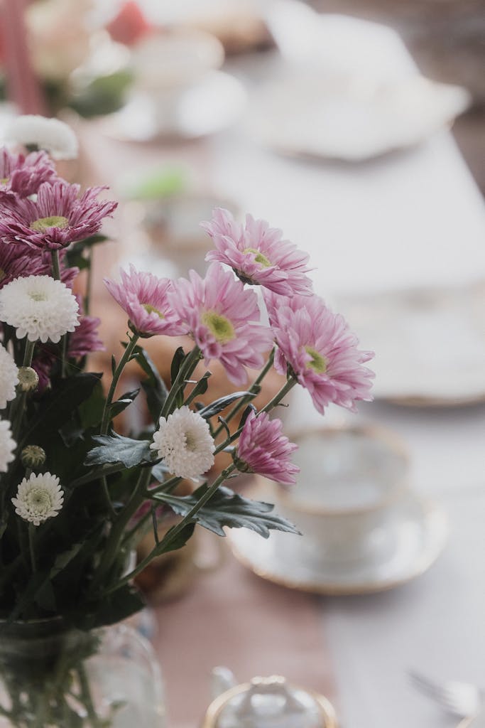 A beautifully arranged table with pink and white florals, perfect for elegant dining settings.